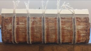 Die angefaserten ersten Lagen werden wieder an den Buchblock angeheftet.